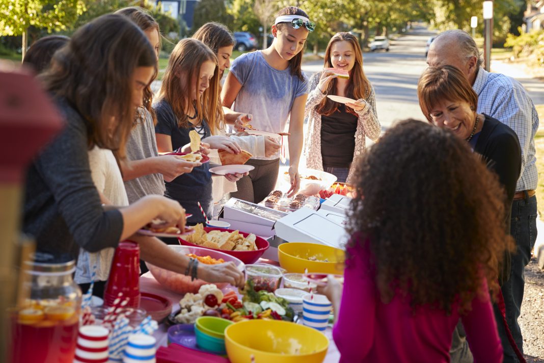 Neighbours standing around a table at a block party