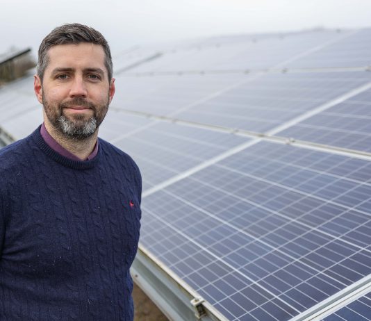 Council Leader Councillor Toby Savage next to solar panels