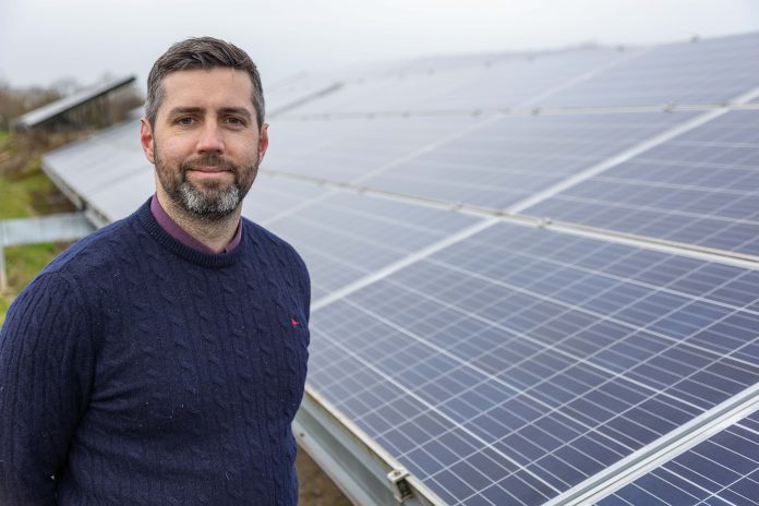 Council Leader Councillor Toby Savage next to solar panels