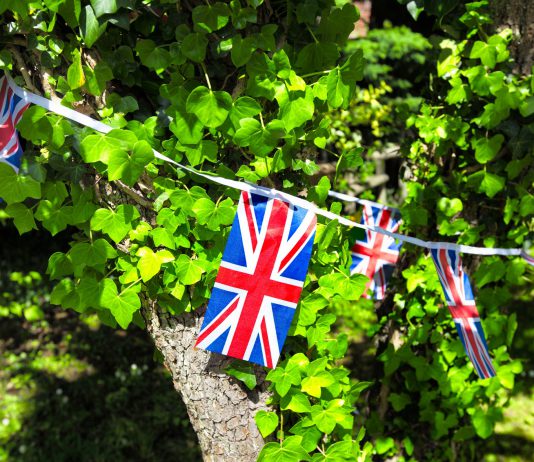 Union Jack bunting wrapped around an apple tree covered in ivy.