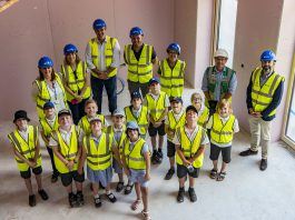 Children and staff join cabinet members at the new school building.