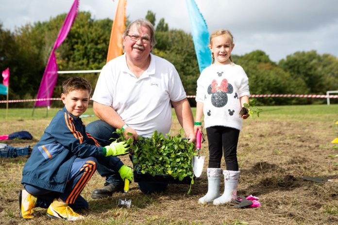 Councillor Reade planting wildflowers with Max and Kady Stuart