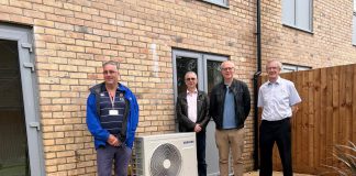 Cllr Monk (left) with colleagues inspecting an air source heat pump installed at the new homes.
