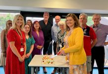 Councillors Louise Harris (right) and Angela Morey (left) cutting a celebration cake, along with other members of the South Gloucestershire Council Administration