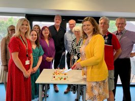 Councillors Louise Harris (right) and Angela Morey (left) cutting a celebration cake, along with other members of the South Gloucestershire Council Administration