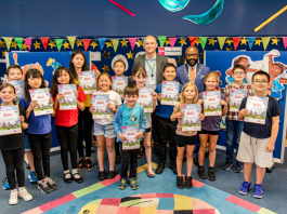 Chair of South Gloucestershire Council, councillor Franklin Owusu-Antwi, and cabinet member with responsibility for libraries, councillor Sean Rhodes, pictured at Bradley Stoke Library with children who took part in the Summer Reading Challenge 2024.