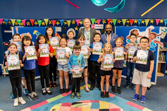 Chair of South Gloucestershire Council, councillor Franklin Owusu-Antwi, and cabinet member with responsibility for libraries, councillor Sean Rhodes, pictured at Bradley Stoke Library with children who took part in the Summer Reading Challenge 2024.