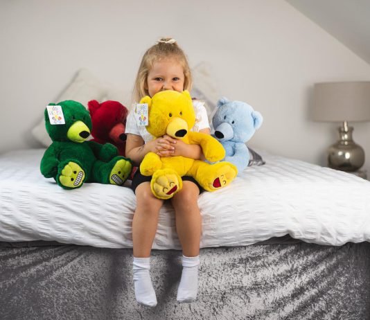 Young girl hugs teddy bear