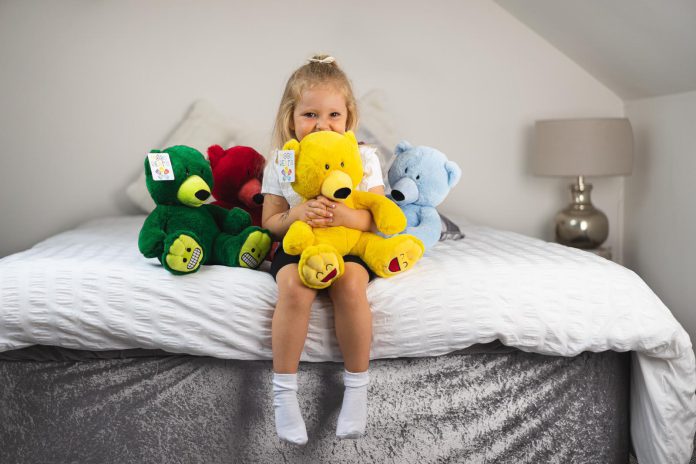 Young girl hugs teddy bear