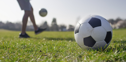 A male kicking a football