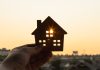 An image of a model of a house held up against the sun