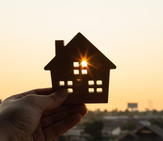 An image of a model of a house held up against the sun