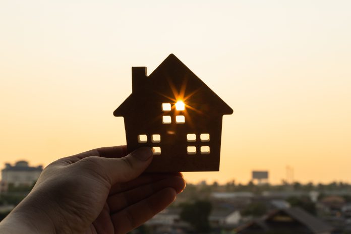 An image of a model of a house held up against the sun