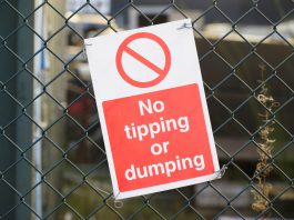 Sign on fence saying No tipping or dumping