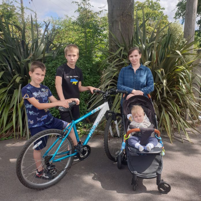 Oksana with children Vladislav, Dmitro and Stanislav and their refurbished bike, donated to them through the Wheels the Work scheme.