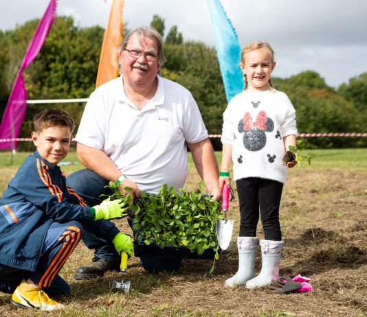 Councillor Reade planting wildflowers with Max and Kady Stuart