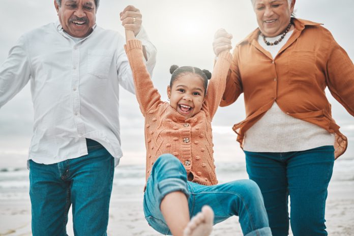 A little girl being swung by her grandparents