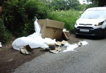 An image of cardboard boxes and packaging waste fly-tipped on the roadside