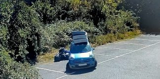 A photo of a car next to several black bin bags in a car park area