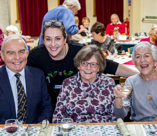 People sat at a social event smiling.