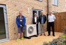 Cllr Monk (left) with colleagues inspecting an air source heat pump installed at the new homes.