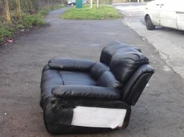 A photograph of a fly-tipped sofa