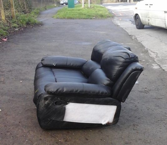 A photograph of a fly-tipped sofa