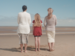 A picture of three people stood on a beach taken from the fostering recruitment film 'Any of Us'.