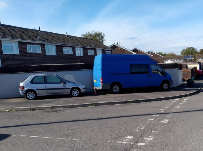 A car and a van parked on a pavement