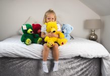 Young girl hugs teddy bear