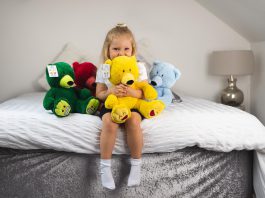 Young girl hugs teddy bear