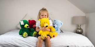 Young girl hugs teddy bear