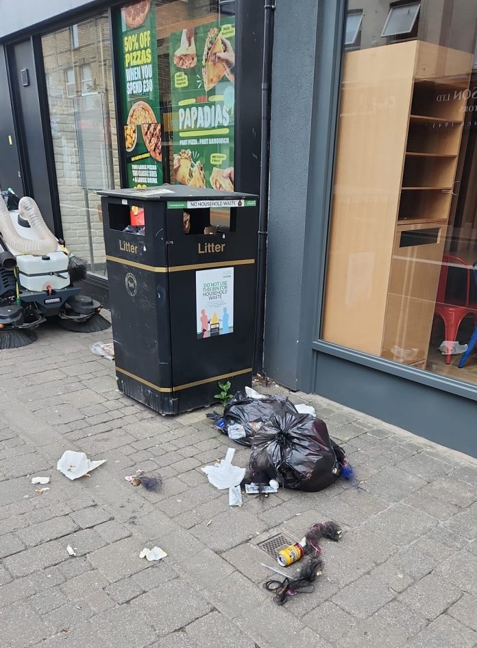 Waste spilling from a black bin bag on the pavement