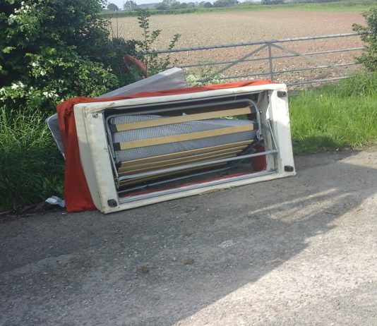 a fly-tipped sofa on the roadside