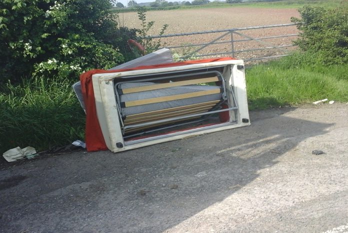 a fly-tipped sofa on the roadside