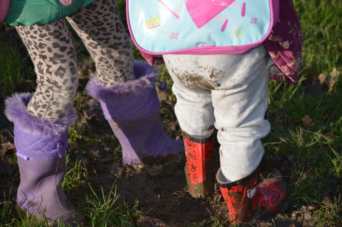 Young children standing in mud