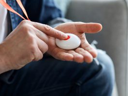 Person pressing button of pendant alarm