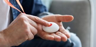 Person pressing button of pendant alarm