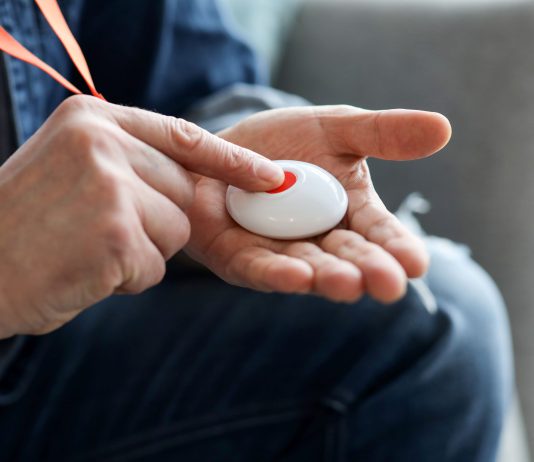 Person pressing button of pendant alarm