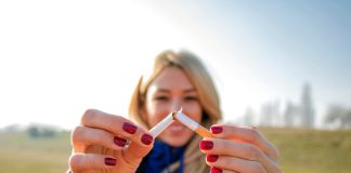 A young woman snapping a cigarette in half