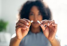 Woman breaking down cigarette to pieces.