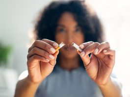 Woman breaking down cigarette to pieces.