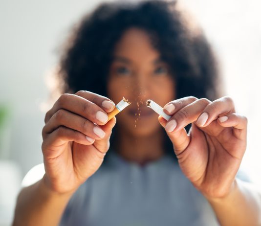 Woman breaking down cigarette to pieces.