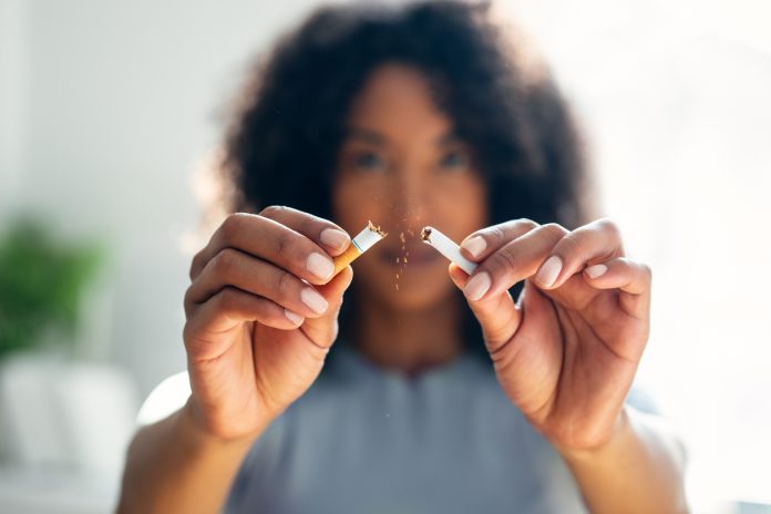 Woman breaking down cigarette to pieces.
