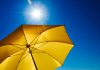 Sunny blue sky and a yellow umbrella shade
