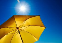 Sunny blue sky and a yellow umbrella shade
