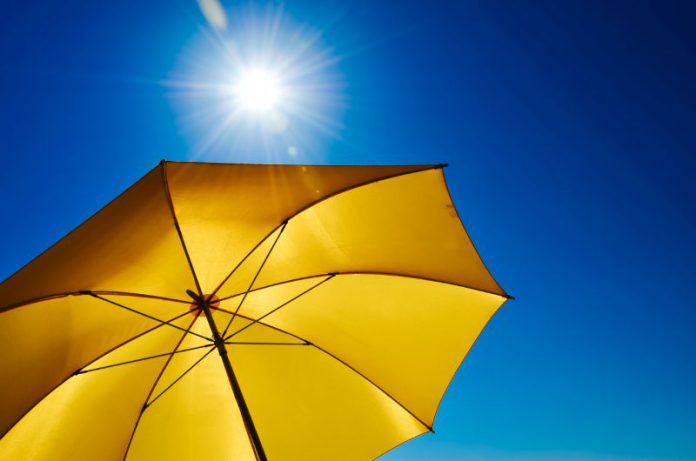 sun and umbrella Sunny blue sky and a yellow umbrella shade