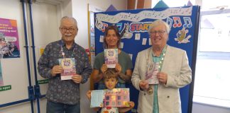 Chair of South Gloucestershire Council, councillor Adrian Rush (right) is joined by a family (centre) and member of staff (left), at Emersons Green Library to mark the launch of the Summer Reading Challenge 2026.