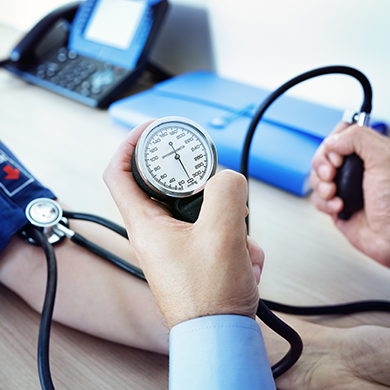 A health professional checking the blood pressure of a patient